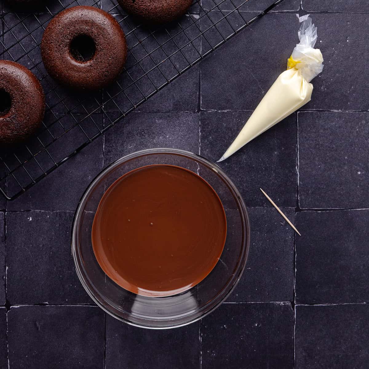 Melted semi-sweet chocolate is in a small bowl and melted white chocolate is in a small piping bag.